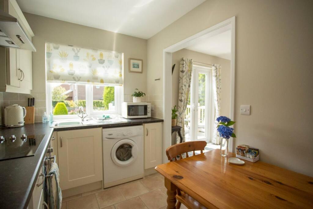 una cocina con fregadero y lavadora en Pant-Y-Celyn Studio Apartment, en Aberaeron
