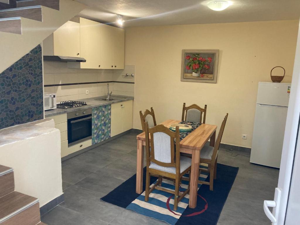 a kitchen with a table and chairs and a refrigerator at Relax and Explore, Alva Apartment in Solin