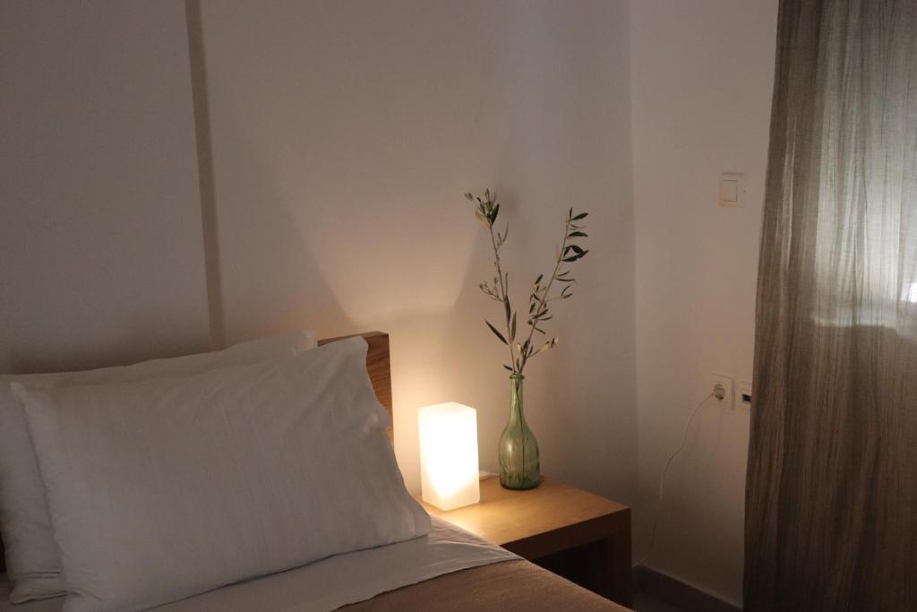 Un dormitorio con una cama y un jarrón con flores. en Zea Apartments, en Himare