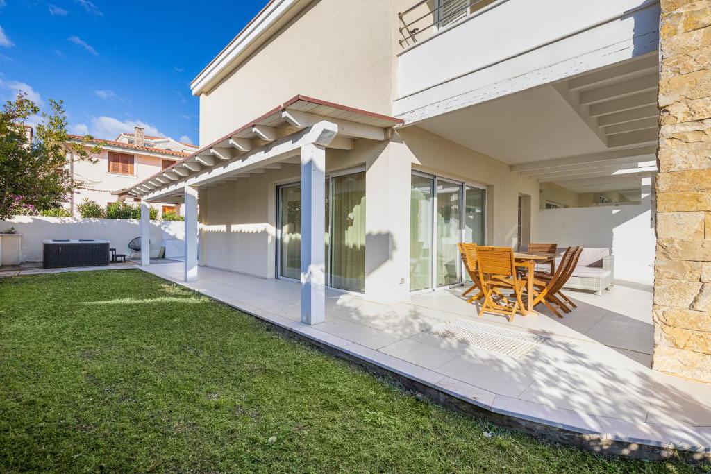 a patio with a table and chairs on a house at Villa Cormorani 1 in Golfo Aranci