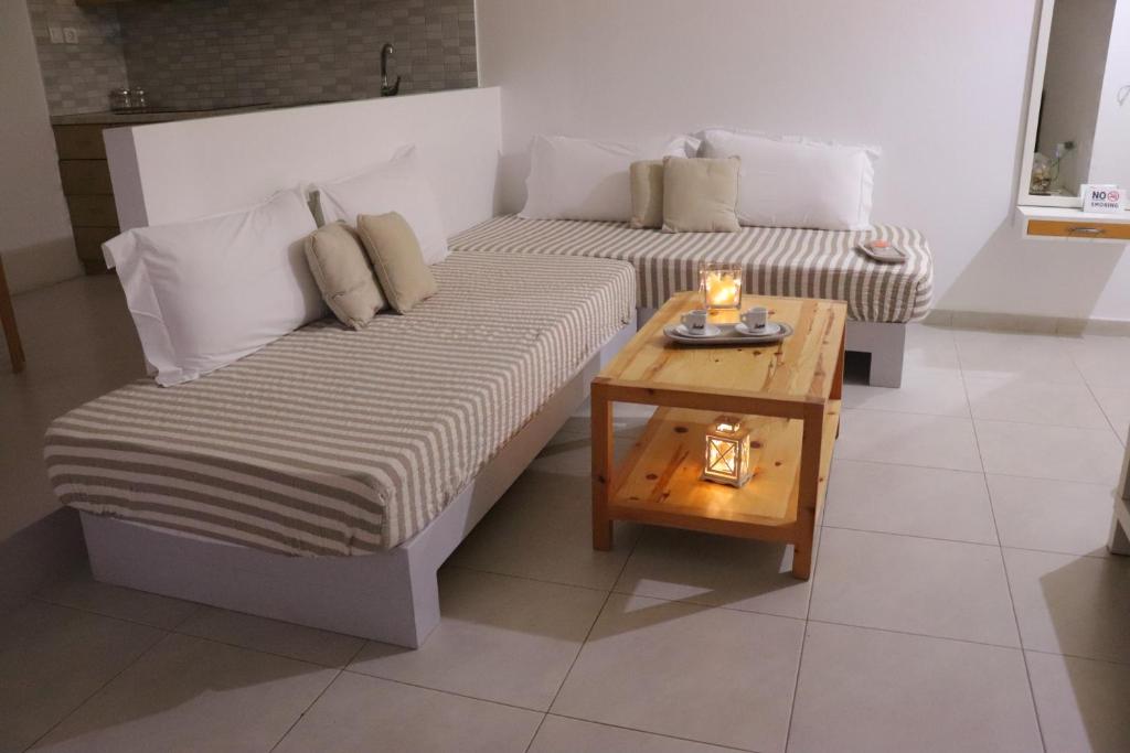 duas camas num quarto com uma mesa em Apartments Piazza em Himare
