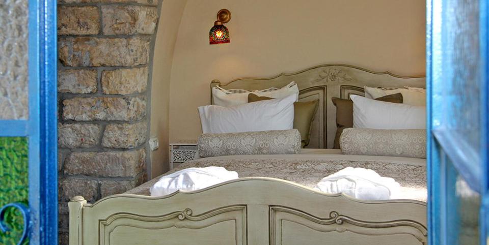 een slaapkamer met een groot bed met witte kussens bij Beit Ha'Omanim in Safed