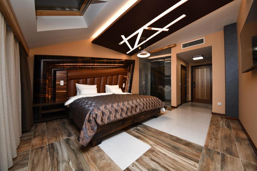 um quarto com uma cama grande e uma lareira em Hotel Havana Loznica em Loznica