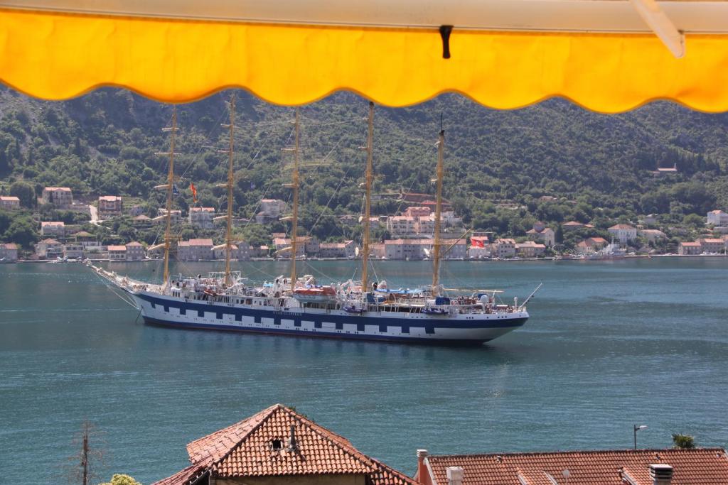 un grand bateau dans l'eau avec une ville dans l'établissement Palma Apartments, à Kotor