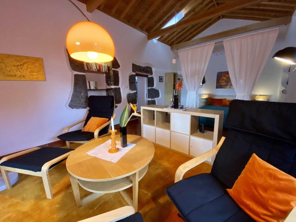 a living room with a table and chairs at Quinta Perpetua, Casa Flores in Santa Cruz da Graciosa