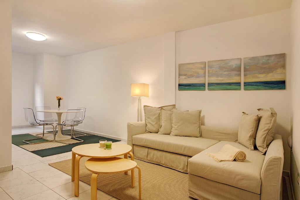 ein Wohnzimmer mit einem Sofa und einem Tisch in der Unterkunft Little Gem in Cruce de Arinaga