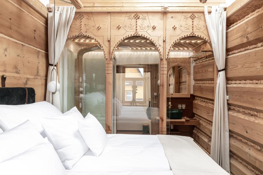 sypialnia z białym łóżkiem i lustrem w obiekcie Villa Milimani - stuletnia, folk & butique, adults only w Zakopanem