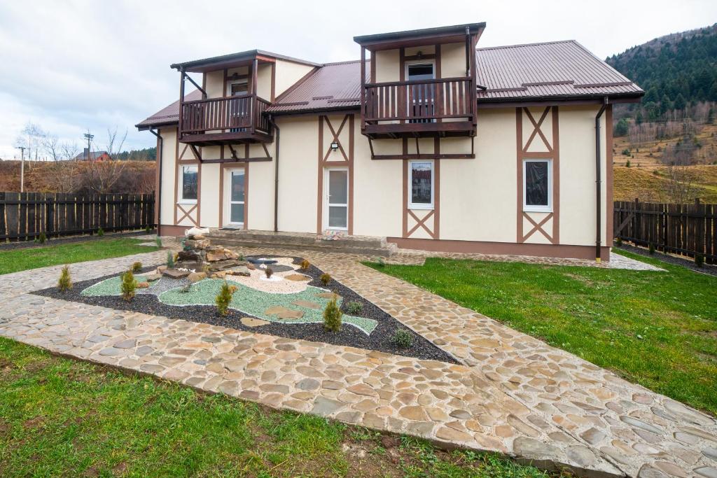 une maison avec un étang en face de celle-ci dans l'établissement Котедж "Під Горбком", à Korchin