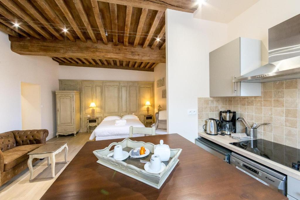 a kitchen and living room with a couch and a table at Le Cara in Beaune