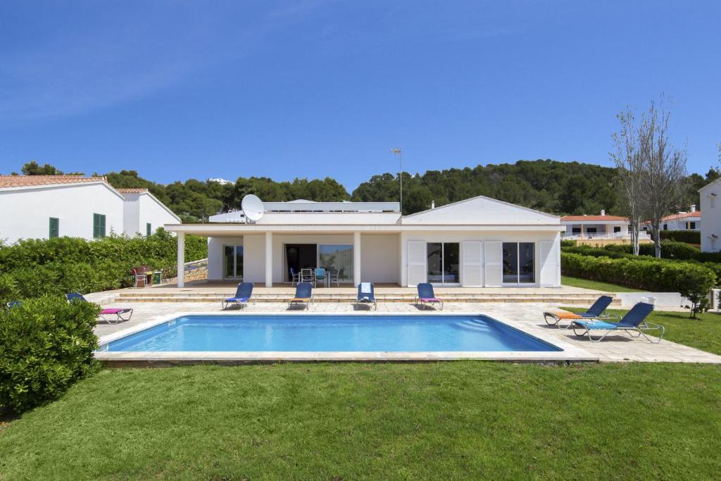 a house with a swimming pool in the yard at Villa Lola in Santo Tomás