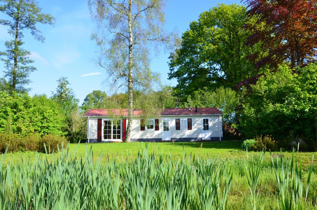 een klein wit huis in het midden van een veld bij Vakantieverblijf Springendalsebeek in Hezingen