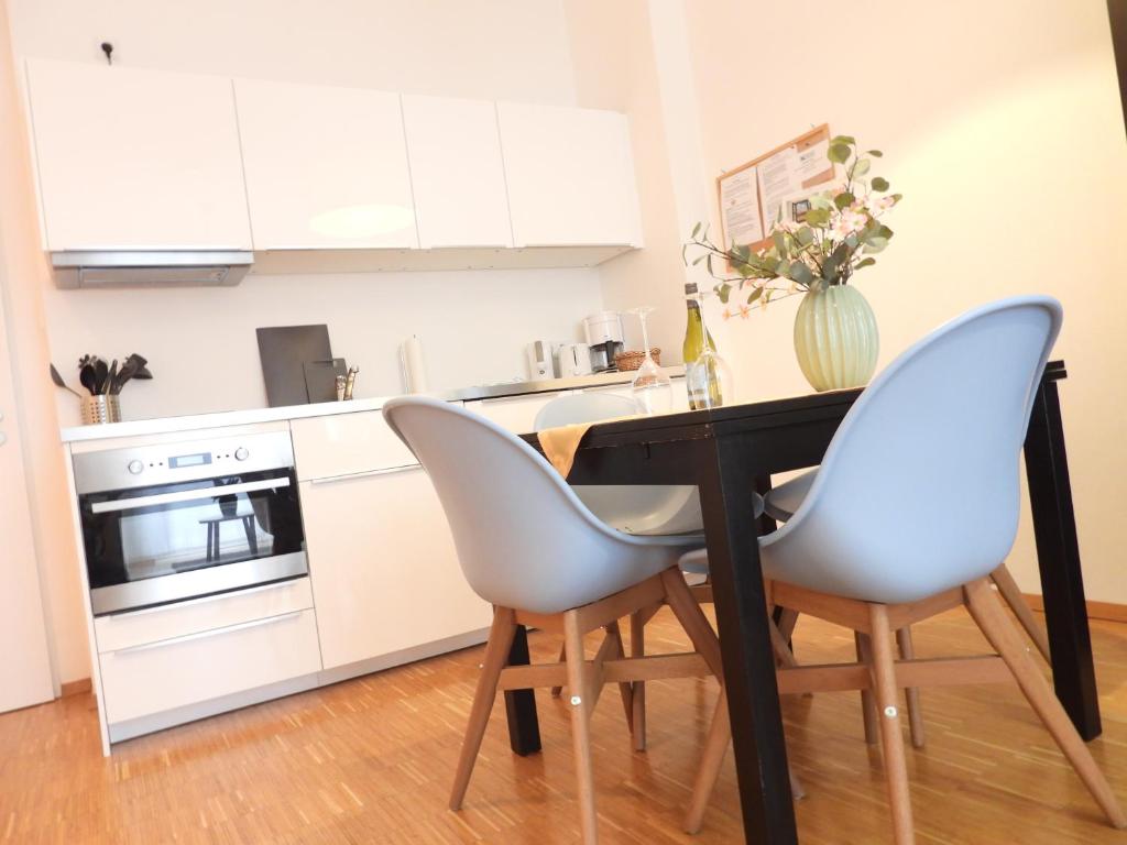 a kitchen with a black table and two chairs at Braviscasa - Ferienresidenz Stadttor Endingen in Endingen