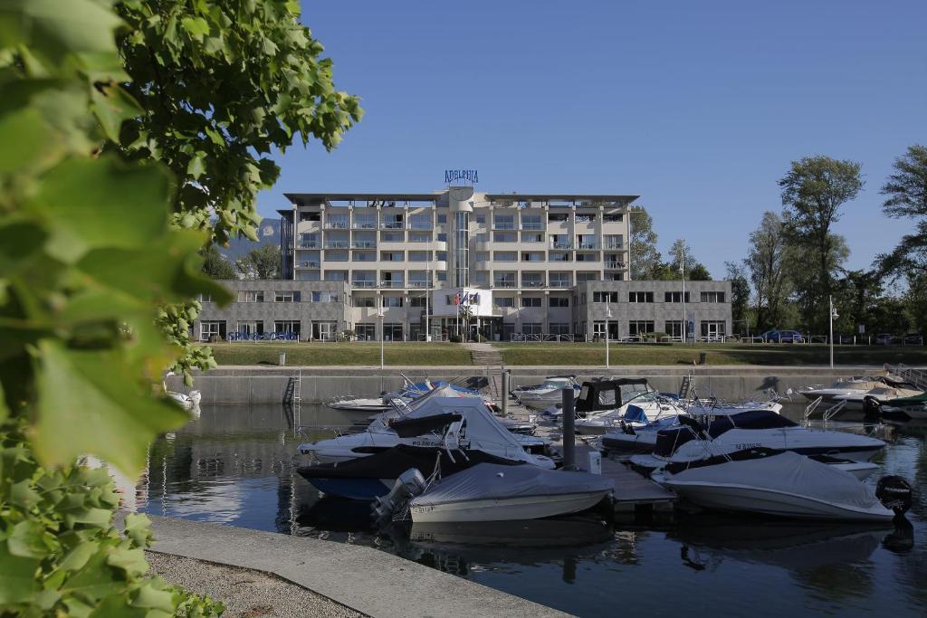 Un montón de barcos atracados en el agua con un edificio en Hotel &amp; Spa Marina d&#39;Adelphia, en Aix-les-Bains