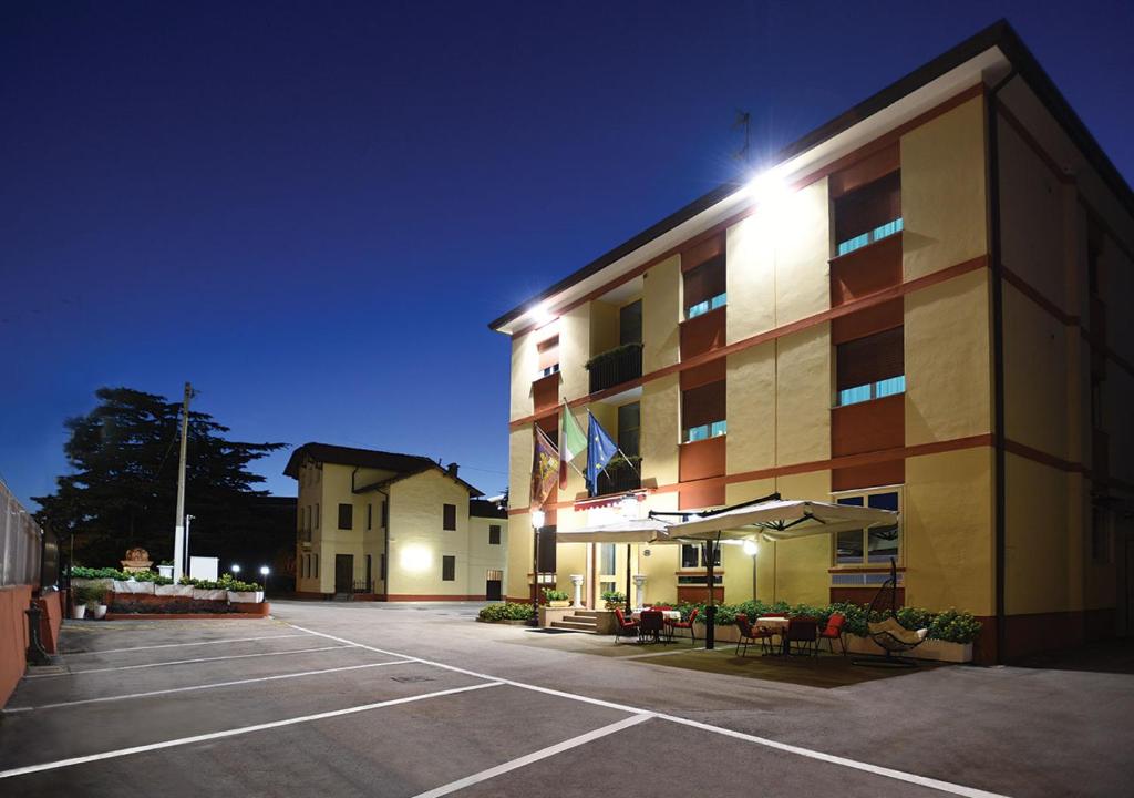 a parking lot in front of a hotel at night at Hotel Autostrada in Padova