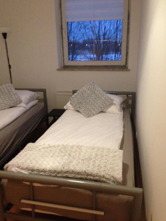a bedroom with two beds and a window at Apartament Centrum Szczytno III in Szczytno