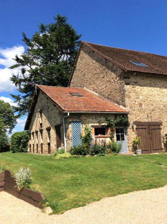 an old stone building with a grass yard at Le Cosy - Domaine du Vertendre in Saint-Yrieix-la-Perche