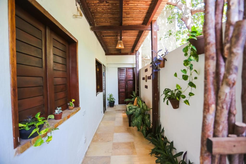 a hallway of a house with plants and a door at Mandala Hostel Jeri in Jericoacoara