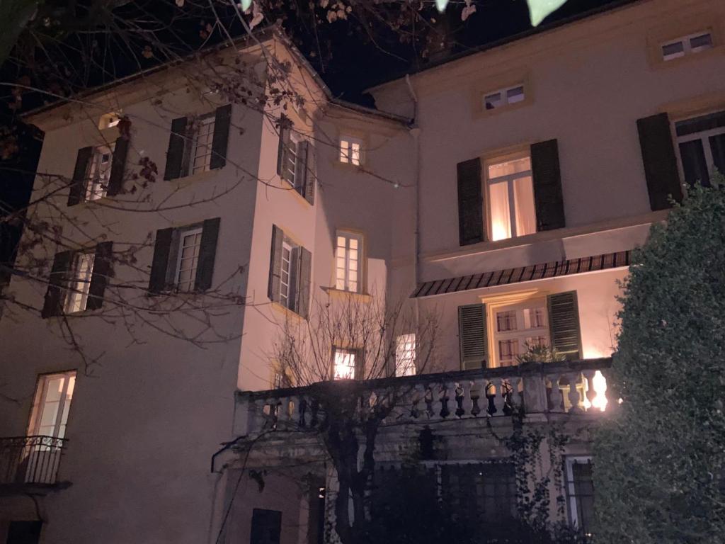 a large white building with a balcony at night at LA TOUR YVELINE in Romans-sur-Isère