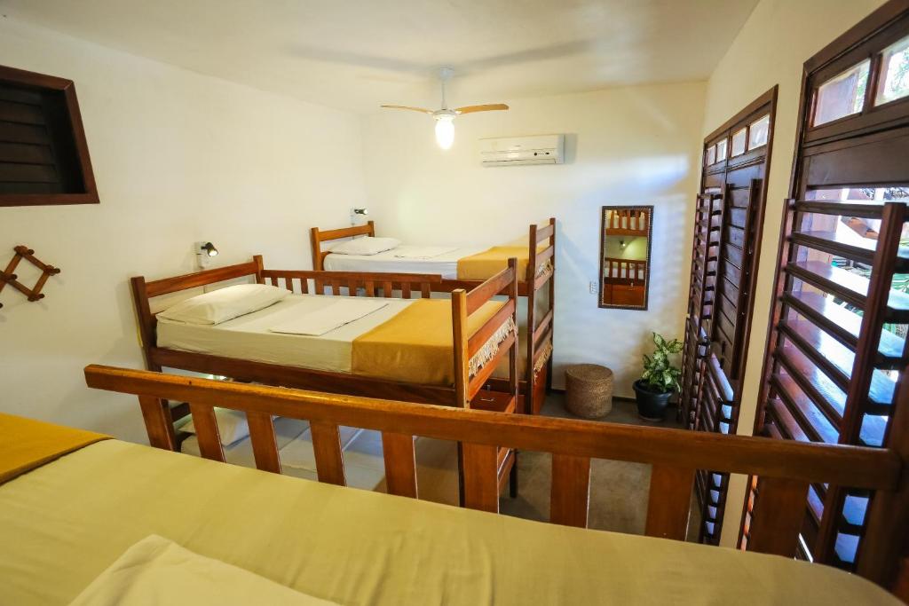a room with three beds in a room at Mandala Hostel Jeri in Jericoacoara