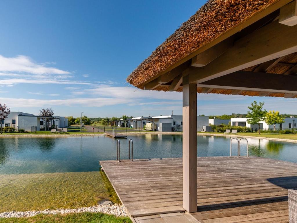a wooden deck with a view of a lake at Heritage Apartment in Lutzmannsburg with Swimming Pond in Zsira