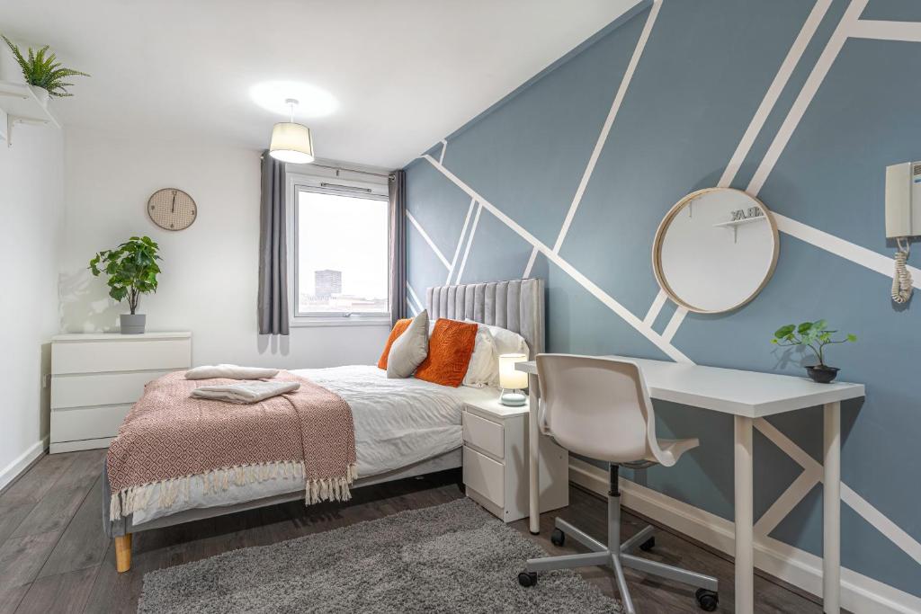 um quarto com uma cama, uma secretária e um espelho em JKG Property Solutions Presents Cosy City Apartment em Coventry