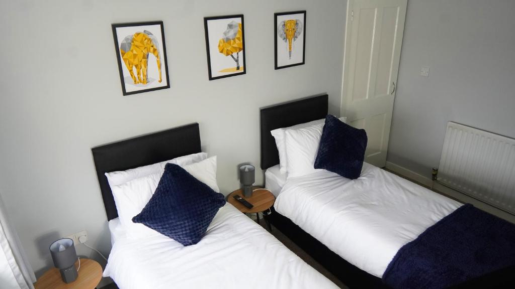 dwa łóżka siedzące obok siebie w sypialni w obiekcie Portobello House - Four Bedroom House perfect for CONTRACTORS - Sleeps 6 - FREE parking w mieście Wolverhampton