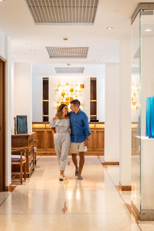 Un uomo e una donna che camminano lungo un corridoio di Art&Park Hotel Union Lido a Cavallino-Treporti
