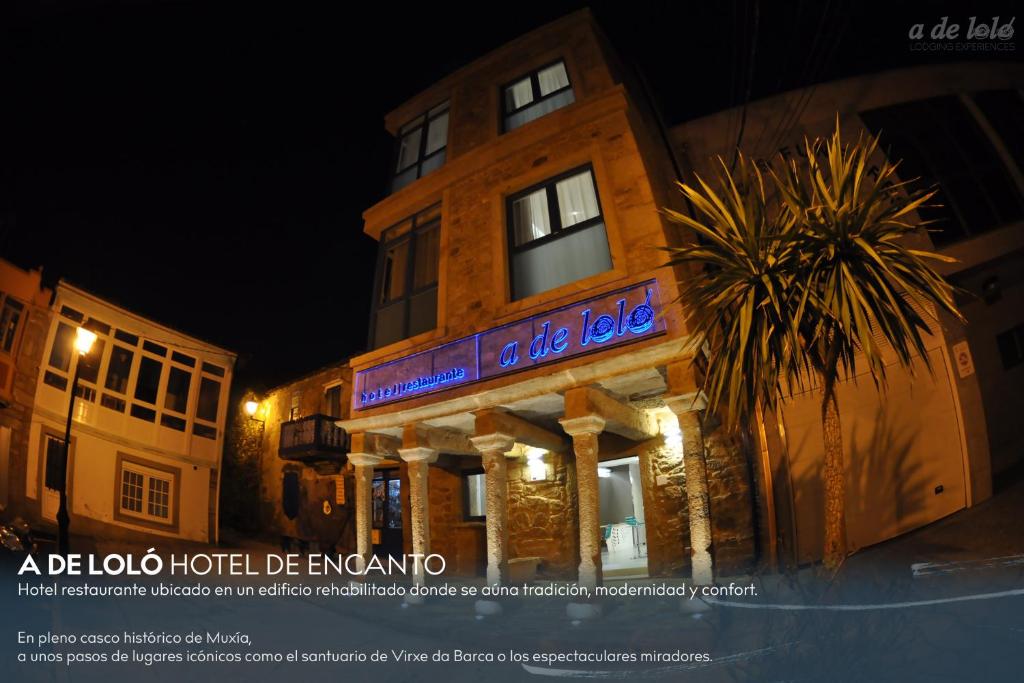 a building with a sign on the side of it at A de Loló Alojamiento con encanto in Muxia