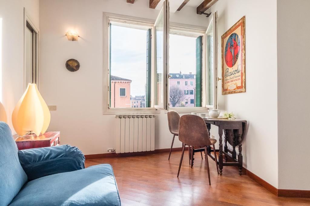 uma sala de estar com um sofá e uma mesa com cadeiras em 7 WINDOWS ON VENICE em Veneza