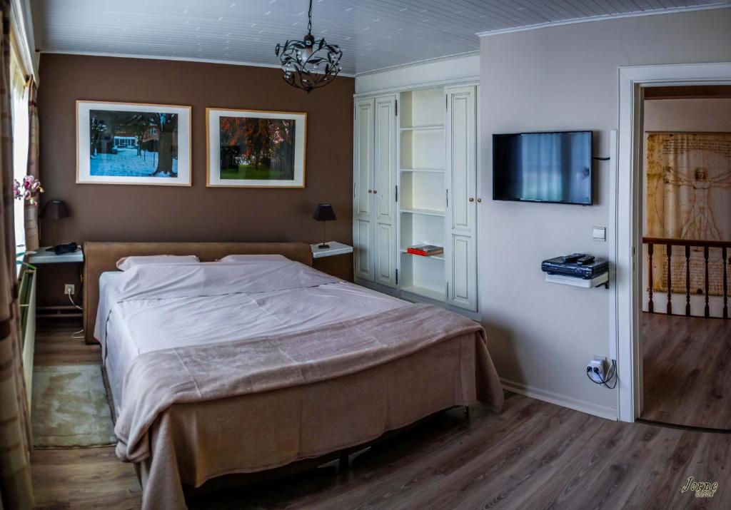 een slaapkamer met een bed en een flatscreen-tv bij B&B Den Boomgaard Moorsel in Moorsel