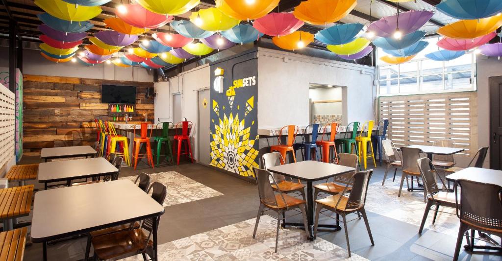 een restaurant met tafels en stoelen onder kleurrijke parasols bij Hostal CASA MX centro in Mexico-Stad
