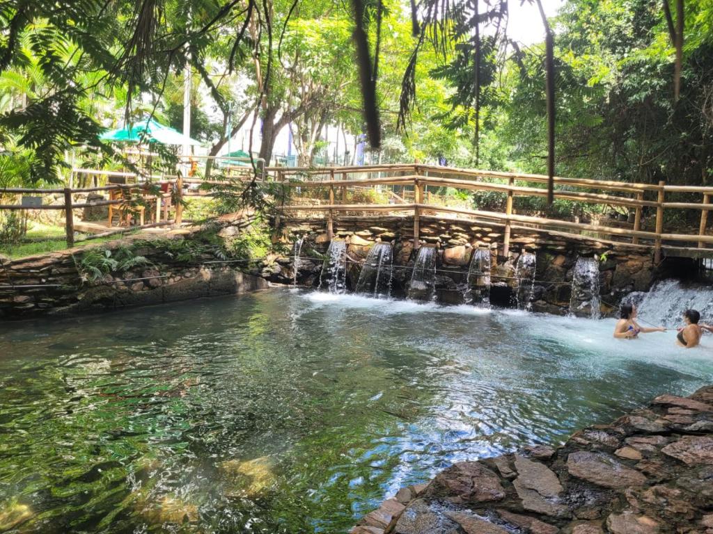 a pool at a waterfall in a park with people in it at Rio Quente Thermas Paradise in Rio Quente