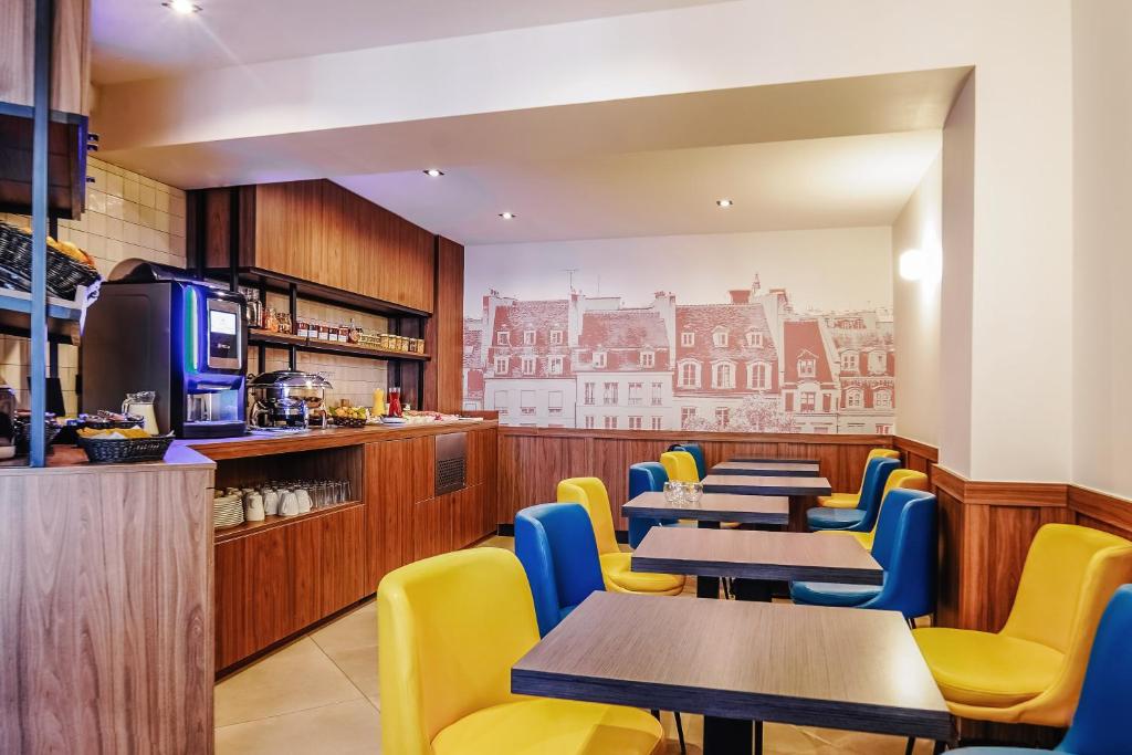a restaurant with tables and chairs and a kitchen at Timhotel Montmartre in Paris