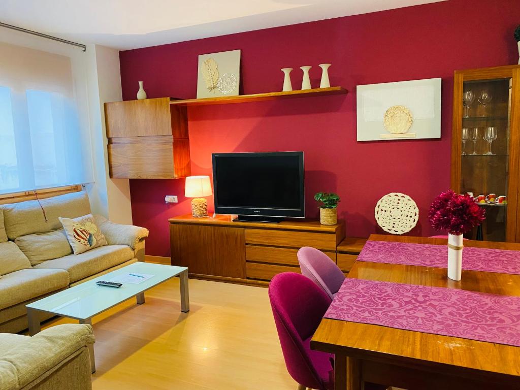 - un salon avec un canapé et une télévision dans l'établissement Apartamentos Alcañiz, Gala, à Alcañiz