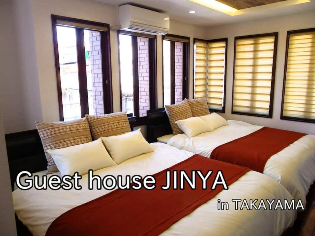 two beds sitting in a room with windows at Guest House Jinya - Vacation STAY 05308v in Takayama