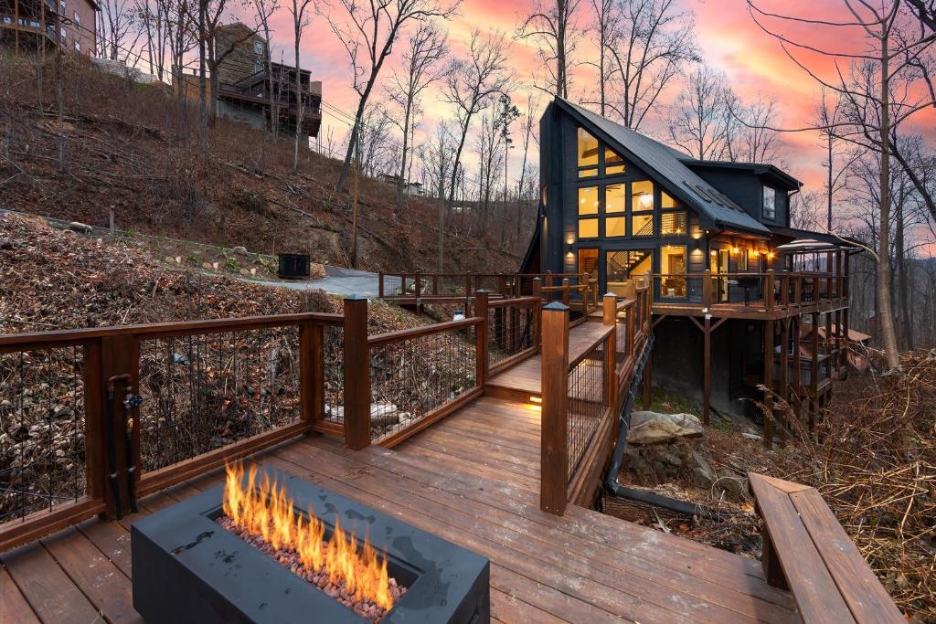 a wooden deck with a fire pit in front of a cabin at Night Owl cabin in Gatlinburg