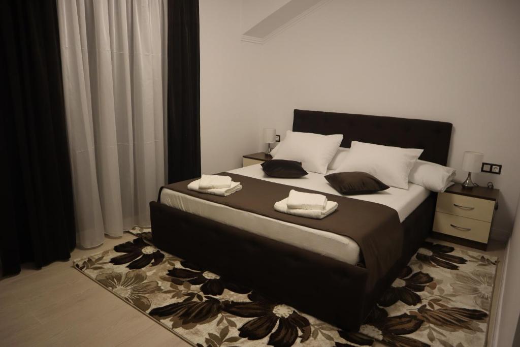 a bedroom with a bed with two towels on it at Pensiunea GOLD Wellness&Spa in Chişcău