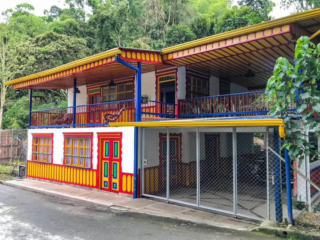 uma casa colorida com uma cerca em frente em Casa de Campo las Serafinas em El Manzano