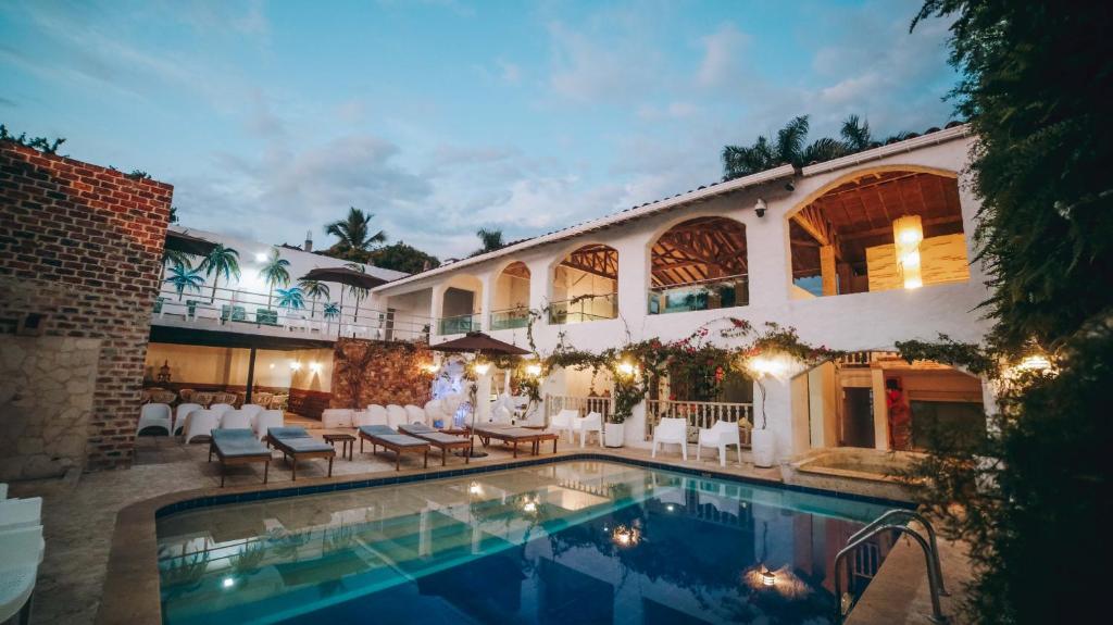 a hotel with a swimming pool in front of a building at Ángel De Santa Fe in Santa Fe de Antioquia