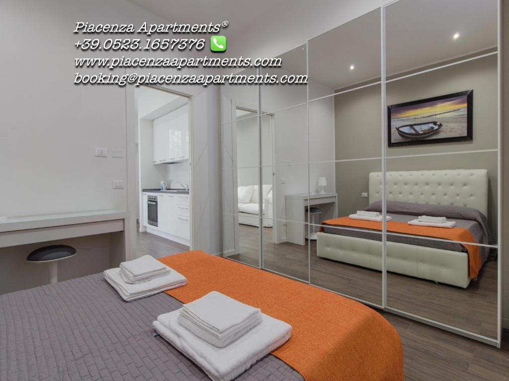 um quarto com uma cama e uma parede de vidro em Malta Guest House Self Check-in em Piacenza