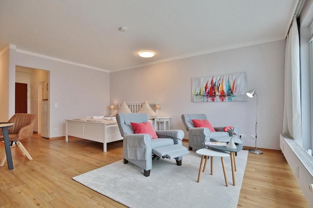 ein Wohnzimmer mit 2 Stühlen und einem Tisch in der Unterkunft Haus Seebrücke Haus Seebrücke Appartement 02 in Niendorf