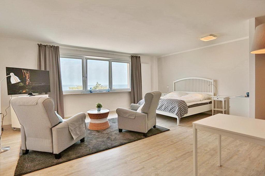 a living room with a bed and two chairs at Haus Seebrücke Haus Seebrücke Appartement 10 in Niendorf