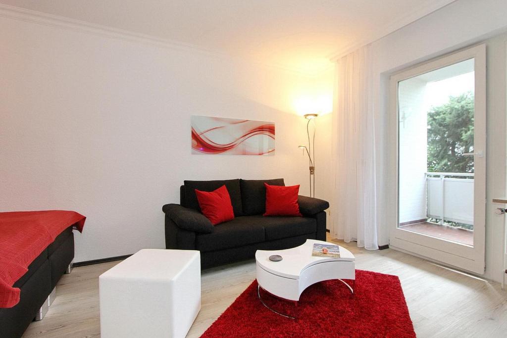 een woonkamer met een bank en een rood tapijt bij Fh Dornkampstraße 1 Ferienhaus Dornkampstrasse 1 Appartement 2 in Timmendorfer Strand