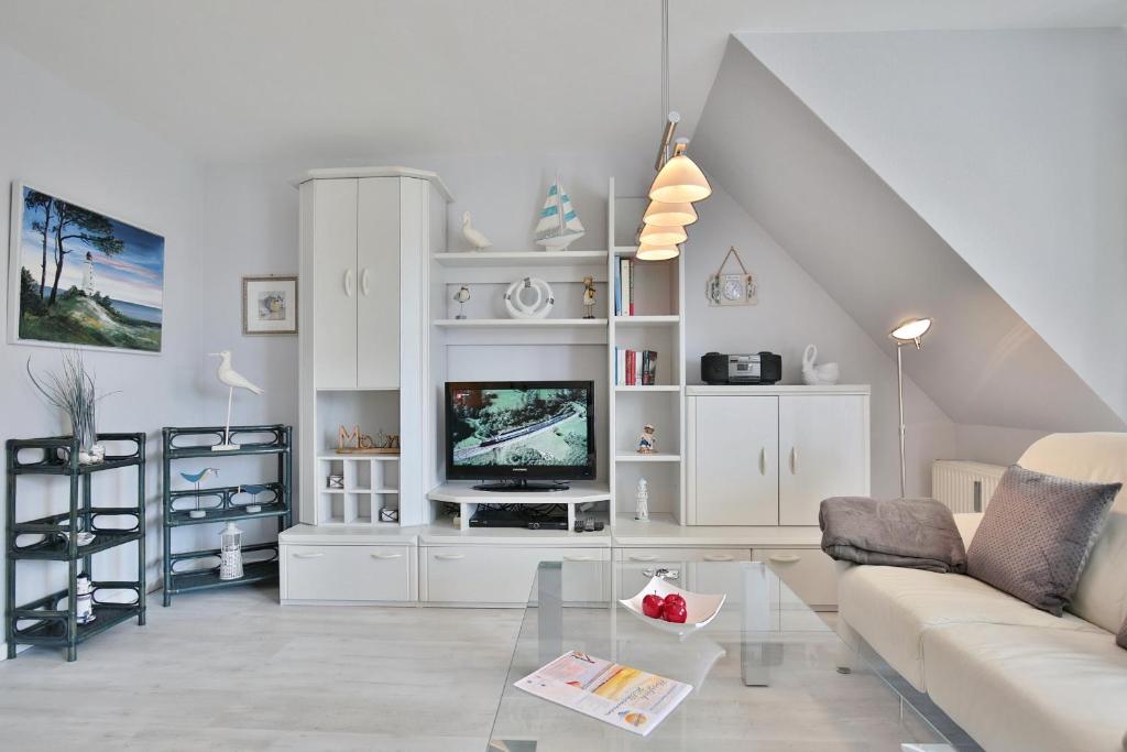 ein Wohnzimmer mit einem Sofa und einem TV in der Unterkunft Im Brook 36-38 Am Elchgrund Appartement 10 in Timmendorfer Strand
