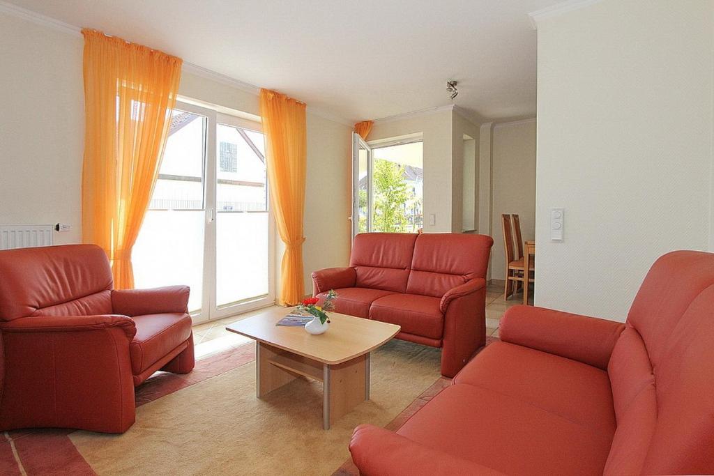 a living room with red chairs and a table at Moderne Strandvilla Moderne Strandvilla Appartement 4 in Timmendorfer Strand