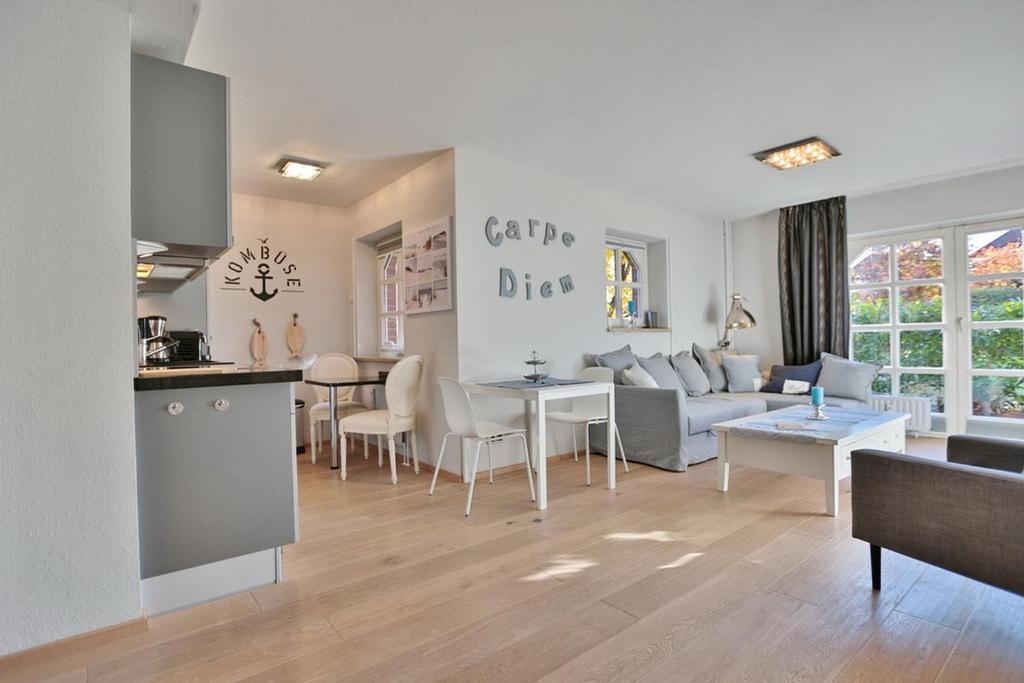 Il comprend un salon et une cuisine avec un canapé et une table. dans l'établissement Am Rosenhain 12 Am Rosenhain 12 Appartement 1, à Timmendorfer Strand