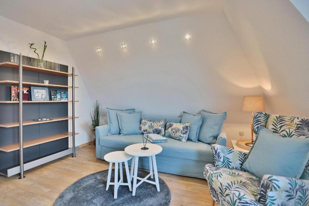 un soggiorno con divano blu e tavolo di Strandschlößchen Strandschlösschen Appartement 15 a Haffkrug