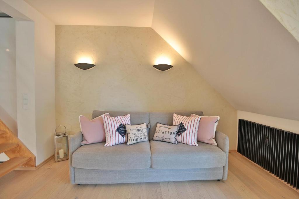 a living room with a couch with pillows on it at Haus am Seehof Seemöwe Appartement 4 in Sierksdorf