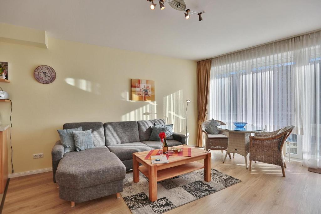 uma sala de estar com um sofá e uma mesa em Barke Barke Appartement 307 em Scharbeutz