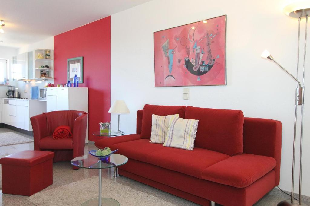 een rode bank en een stoel in de woonkamer bij Residenz Ostseestrand Residenz Ostseestrand Appartement 23 in Scharbeutz